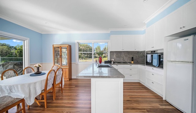 A beautiful new 5 bedroom farmhouse with an in-ground pool surrounded by nature